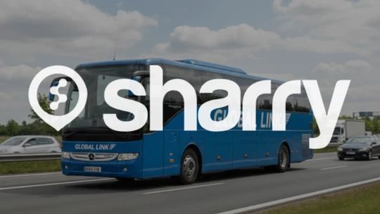 logo i nazwa firmy Sharry na tle niebieskiego autobusu sfotografowanego z boku