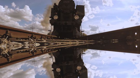 lokomotywa parowa w trakcie jazdy po szynach